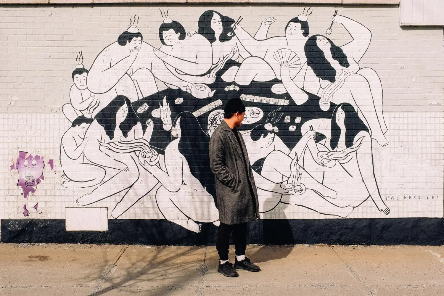Person standing in front of a large black and white street mural