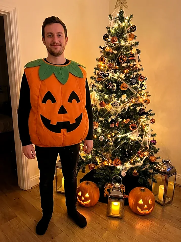 Man in a playful orange pumpkin costume beside a decorated black Halloween tree, generated by the Halloween photo pack